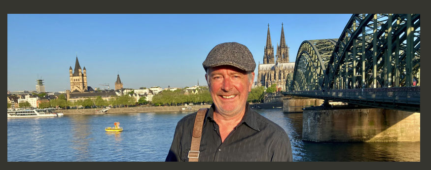 Berno Maria Hübinger vor Kölner Dom und Hohenzollernbrücke am Rhein